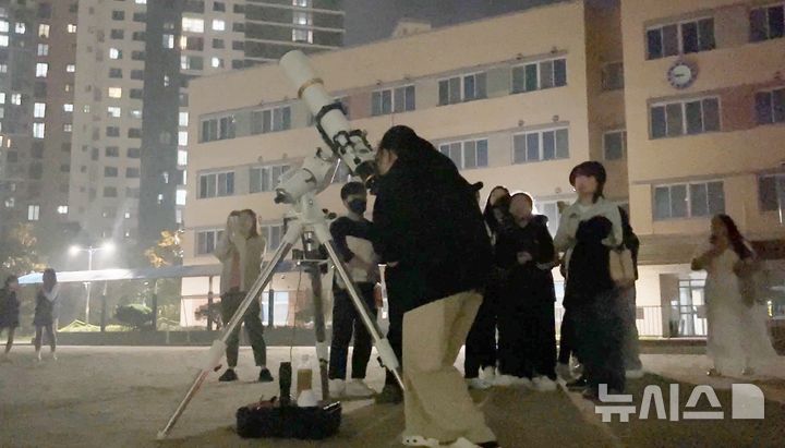 [화성=뉴시스] 화성 수현중학교가 15일 학교에서 '나랑 별 보러 가지 않을래?'행사를 개최, 학생과 학부모들이 망원경으로 천체를 관측하고 있다.(사진=화성오산교육지원청 제공)2024.10.16.photo@newsis.com