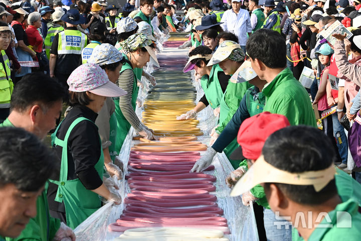 [이천=뉴시스] 김종택기자 = '제23회 이천 쌀 문화축제'가 열린 16일 경기도 이천시 모가면 이천농업테마공원에서 600m 오색 가래떡 만들기가 진행되고 있다. 2024.10.16. jtk@newsis.com