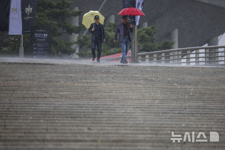 [서울=뉴시스] 정병혁 기자 = 비가 내린 18일 서울 마포구 서울월드컵경기장 인근에서 우산을 쓴 시민들이 이동하고 있다. 2024.10.18. jhope@newsis.com