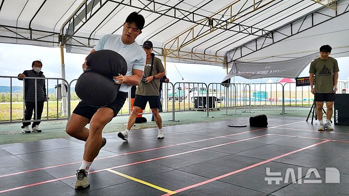 [논산=뉴시스] 송승화 기자 = 19일 충남 논산시 강경읍 금강변 특별무대에서 아페고월드와 뉴시스 대전충남본부가 공동 주최·주관한 '배틀크루' 최종 예선에서 한 참가 선수가 45㎏ 모래주머니를 들고 시간 단축을 위해 뛰고 있다. 2024.10.19. ssong1007@newsis.com