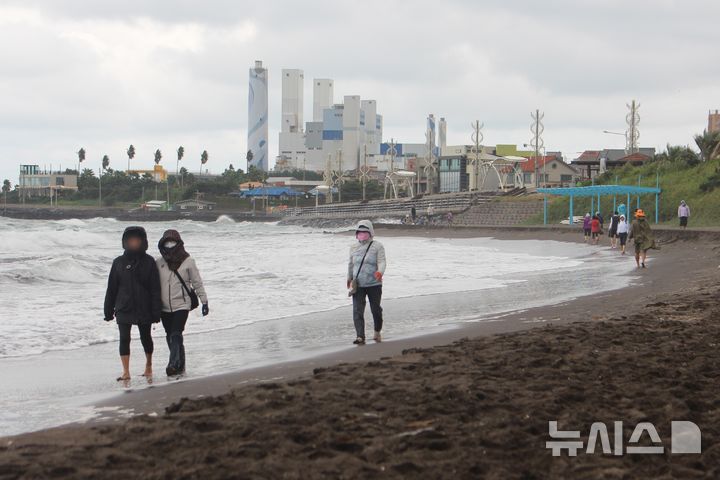 [제주=뉴시스] 양영전 기자 = 흐린 날씨를 보인 19일 오후 제주시 삼양해수욕장 검은모래해변을 찾은 시민들이 맨발 걷기를 하고 있다. 2024.10.19. 0jeoni@newsis.com 