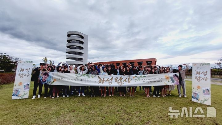 [화성=뉴시스] 화성탐사 참가자들이 19일 플래카드를 펼치고 기념촬영을 하고 있다.(사진=화성시 제공)2024.10.21.photo@newsis.com