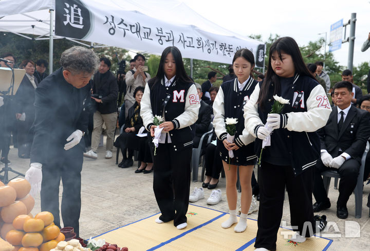 [서울=뉴시스] 김명년 기자 = 21일 오전 서울 성동구 성수대교 북단 인근 성수대교 사고 희생자 위령비에서 열린 제30주기 합동위령제에서 무학여고 학생들이 헌화하고 있다. 성수대교 붕괴사고는 30년 전인 1994년 10월21일 오전 성수대교 상부가 무너지며 당시 등교중이던 무학여고 학생 8명 포함 시민 32명이 사망하고 17명이 다친 사고다. 2024.10.21. kmn@newsis.com