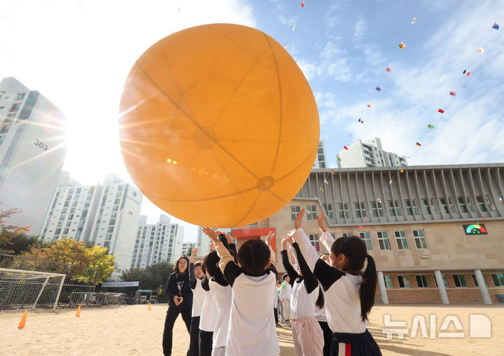 [인천=뉴시스] 전진환 기자 =  21일 오전 인천 부평구 부곡초등학교에서 열린 가을운동회에서 어린이들이 머리위로 볼 나르기를 하고 있다. 2024.10.21. amin2@newsis.com