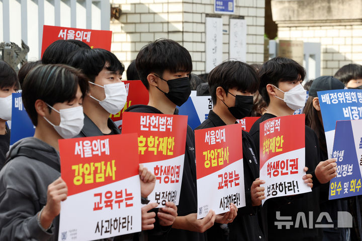 [서울=뉴시스] 김명년 기자 = 서울대학교 의과대학 학생들이 지난 21일 서울 종로구 서울대의대 앞에서 열린 ‘서울의대에 대한 교육부의 폭압적인 감사 규탄 집회’에서 피켓을 들고 침묵시위를 하고 있다. 2024.10.23. kmn@newsis.com