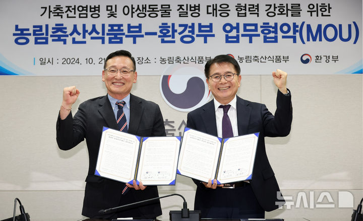 [세종=뉴시스] 강종민 기자 = 지난해 10월 세종시 정부세종청사에서 열린 가축전염병 및 야생동물 질병 대응 협력 강화를 위한 농림축산식품부-환경부 업무협약식에서 최정록 농식품부 방역정책국장(오른쪽)과 김태오 환경부 자연보존국장이 협약서에 서명한 뒤 기념촬영을 하고 있다. 2024.10.21. ppkjm@newsis.com