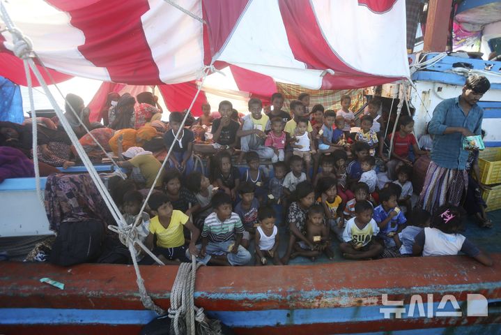 [라부한 하즈=AP/뉴시스]2024년 10월22일 인도네시아 아체주 라부한 하즈 해안 인근에 정박한 선박 갑판에서 로힝야 난민 어린이들이 현지 어민들이 가져다줄 음식을 기다리고 있다. 유엔 난민기구 및 국제이주기구에 따르면, 최근 안다만해에서 말레이시아로 향하던 보트가 전복돼 로힝야 난민과 방글라데시 국민 등 최소 250명이 실종됐다. 2026.04.15.