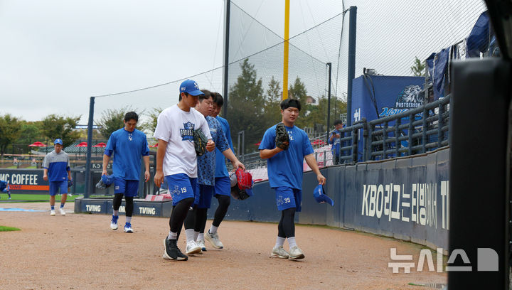 [광주=뉴시스] 전신 기자 = 2024 KBO 포스트시즌 한국시리즈 1차전 서스펜디드 경기 및 2차전이 그라운드 정비 및 비 예보로 순연된 22일 광주 북구 광주-기아챔피언스필드에서 몸을 풀던 삼성 선수들이 더그아웃으로 향하고 있다. photo1006@newsis.com