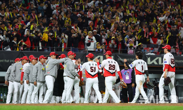 [광주=뉴시스] 전신 기자 = 23일 광주 북구 광주-기아챔피언스필드에서 열린 2024 KBO 포스트시즌 한국시리즈 2차전 삼성 라이온즈와 KIA 타이거즈의 경기에서 8-3 승리한 KIA 이범호 감독이 선수들과 하이파이브를 하고 있다. photo1006@newsis.com