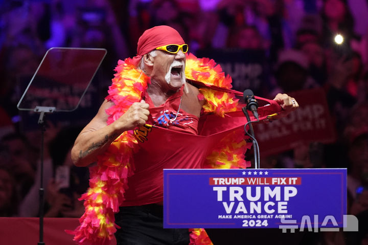 [뉴욕=AP/뉴시스] 전 프로레슬러 헐크 호건이 27일(현지시각) 미국 뉴욕의 매디슨 스퀘어 가든에서 열린 공화당 대선 후보 도널드 트럼프 전 대통령의 유세 무대에 올라 지지 연설 전 상의를 찢고 있다. 2024.10.28.