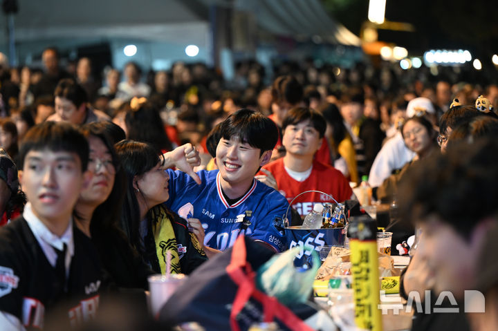 [광주=뉴시스] 박기웅 기자 = 2024 KBO 포스트시즌 한국시리즈 5차전 삼성 라이온즈와 KIA 타이거즈의 경기가 열린 28일 오후 광주 서구 김대중컨벤션센터 야외광장에서 1회초 삼성이 연타석 홈런을 기록하며 앞서자 한 삼성 팬이 지인을 놀리고 있다. 2024.10.28. pboxer@newsis.com