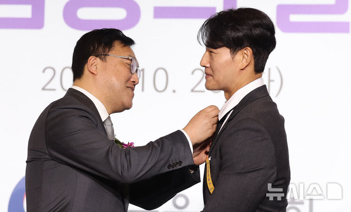 [서울=뉴시스] 추상철 기자 = 김병환 금융위원장이 29일 서울 영등포구 여의도 FKI타워 컨퍼런스센터에서 열린 '제9회 금융의 날 기념식'에서 가수 김종국에게 대통령 표창을 전달하고 있다. 2024.10.29. scchoo@newsis.com