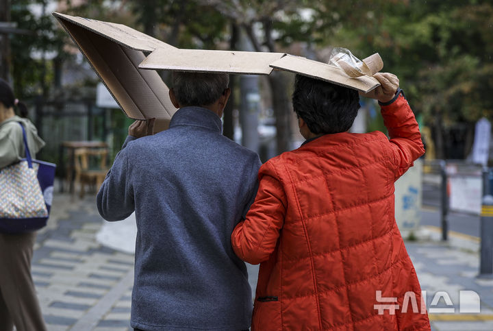 [서울=뉴시스] 정병혁 기자 = 전문가들은 부부처럼 가까운 사이일수록 상대를 존중하고 배려해야 한다고 강조했다. 사진은 비가 내린 지난달 29일 서울 종로구 필운대로 인근에서 우산이 없는 시민들이 박스로 머리를 가린 채 이동하고 있는 모습. 2024.10.29. jhope@newsis.com