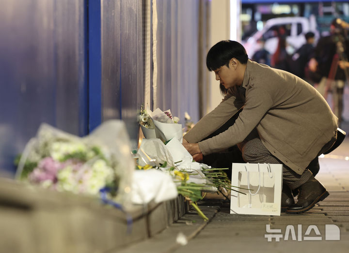 [서울=뉴시스] 김근수 기자 = 10.29 이태원 참사 2주기인 지난해 10월 29일 서울 용산구 이태원 참사 추모거리에서 퇴근한 한 시민이 희생자들을 추모하고 있는 모습. 2024.10.29. ks@newsis.com