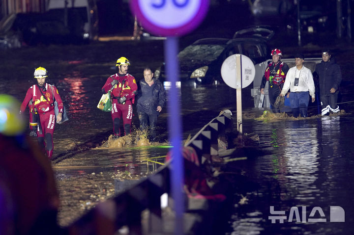 [발렌시아=AP/뉴시스] 30일(현지시각) 스페인 발렌시아에서 구조대가 홍수로 집 안에 고립됐던 주민들을 구조해 안전한 곳으로 나오고 있다. 스페인 남동부에 29일 하루 만에 한 달 치 폭우가 쏟아져 피해가 속출한 것으로 알려졌다. 2024.10.30.