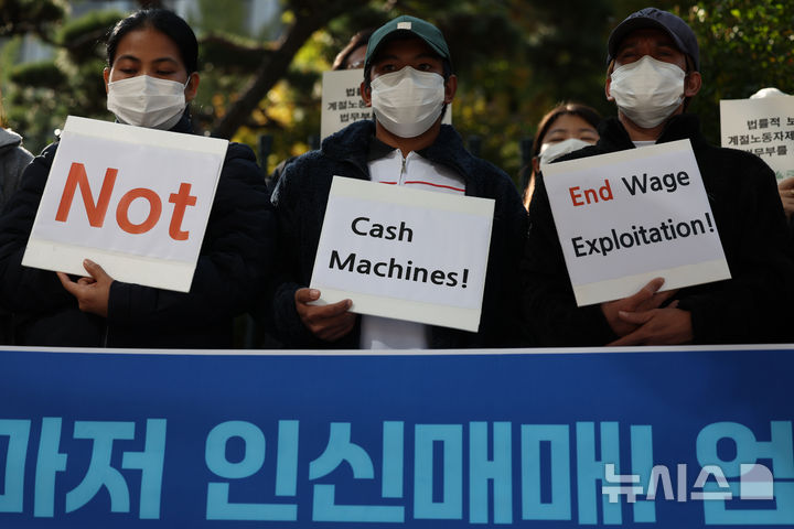 [서울=뉴시스] 김금보 기자 = 이주인권단체와 임금 착취·인신매매 피해 이주노동자들이 지난해 10월30일 서울 서대문구 경찰청 앞에서 열린 '공공형마저 인신매매! 엄중수사 촉구! 임금 착취 만연한 계절노동자제도 규탄 기자회견'에서 손피켓을 들고 있다. 2024.10.30. kgb@newsis.com