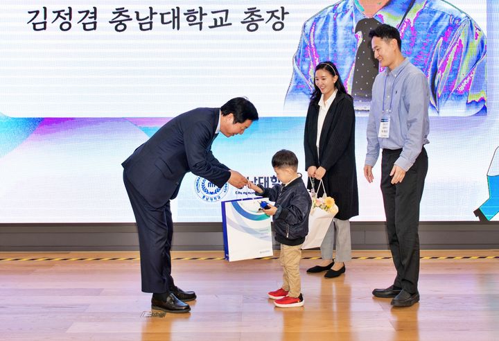 [대전=뉴시스] 30일 대전 유성구 충남대학교에서 열린 신임 교원 간담회에서 김정겸 총장이 신임 교원 자녀에게 대학에서 마련한 선물을 전달하고 있다. (사진=충남대 제공) 2024.10.31. photo@newsis.com  *재판매 및 DB 금지