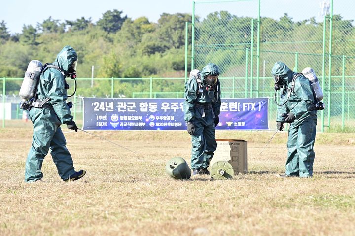 [서울=뉴시스] 우주물체가 대한민국 영토에 추락하는 상황을 부여해 공군 제20전투비행단 관계관들이 지면 출돌 현장에 출동해 방사능 탐지, 폐기물 수거 등을 조치하고 있다. (사진=합동참모본부 제공) 2024.10.31. photo@newsis.com *재판매 및 DB 금지