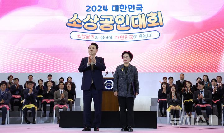 [고양=뉴시스] 조수정 기자 = 윤석열 대통령이 31일 경기 고양시 일산 킨텍스에서 열린 2024 대한민국 소상공인대회 개막식에 참석해 라복임플로체 라복임 대표에게 대통령 표창을 수여한 뒤 기념촬영을 하고 있다. 2024.10.31. chocrystal@newsis.com