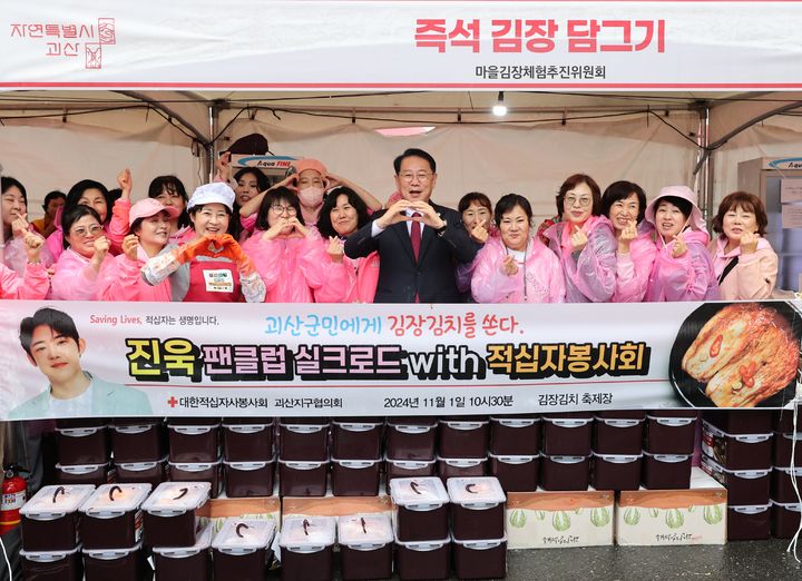 [괴산=뉴시스] 1일 가수 진욱의 팬클럽 ‘실크로드’ 회원들이 '2024괴산김장축제'가 열리고 있는 충북 괴산군 괴산읍 괴산유기농엑스포광장에서 직접 담근 300만원 상당의 김치를 송인헌 괴산군수와 대한적십자봉사회 괴산군지회에 전달하고 있다. (사진=괴산군 제공) 2024.11.01. photo.newsis.com  *재판매 및 DB 금지