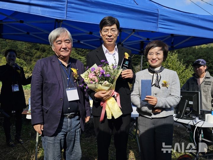 [의령=뉴시스] 고려대학교 국문과 최동호(왼쪽) 명예교수(왼쪽)가 백남경(가운데) 수필가에게 제10회 진등재문학상 상패를 수여한 후 함영희 경남특수교육원 원장과 기념촬영하고 있다.(사진=진등재문학회 제공)2024.11.05. photo@newsis.com