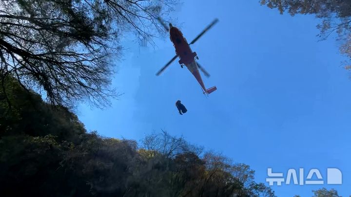 [제주=뉴시스] 6일 오전 제주시 한라산 천아계곡 인근에서 소방당국이 낙상사고로 부상을 입은 등산객을 헬기로 이송하고 있다. (사진=제주소방안전본부 제공) 2024.11.06. photo@newsis.com 