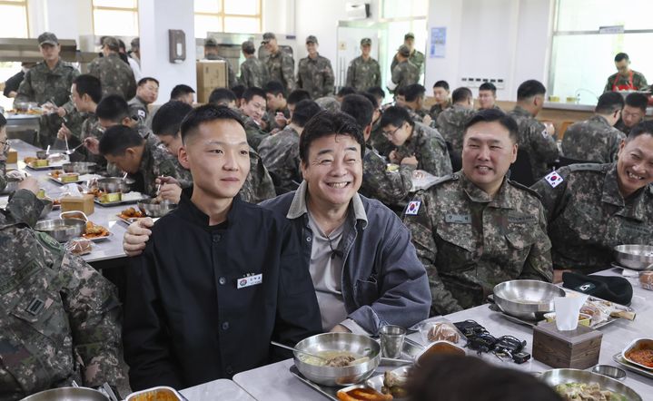 [서울=뉴시스] 7일 육군 7포병여단 758대대에서 진행된 더본코리아의 특식 제공 행사에서 백종원 더본코리아 대표와 조리병 김태윤 병장이 기념촬영 하고 있다. (사진=국방일보 제공) 2024.11.07. photo@newsis.com *재판매 및 DB 금지