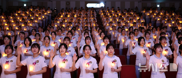 [인천=뉴시스] 전진환 기자 = 8일 오후 인천 연수구 가천대학교 메디컬캠퍼스에서 열린 제77회 나이팅게일 선서식에서 임상실습을 앞둔 간호대학 2학년 학생들이 촛불을 들고 선서를 하고 있다.  2024.11.08. amin2@newsis.com