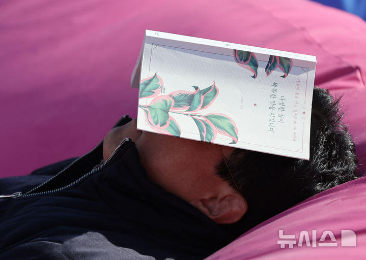 [서울=뉴시스] 김금보 기자 = 서울 낮 기온이 17까지 오르며 포근한 늦가을 날씨를 보인 8일 서울 중구 책읽는 서울광장을 찾은 시민들이 가을볕에 휴식을 취하고 있다. 2024.11.08. kgb@newsis.com