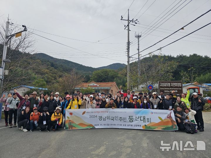 [창원=뉴시스]10일 경남 고성군 고성갈모봉 자연휴양림 입구에서 경남외국인주민지원센터 주관 '경남 외국인주민 등산대회'에 참여한 외국인주민들이 기념촬영하고 있다.(사진=경상남도외국인주민지원센터 제공02024.11.10. photo@newsis.com