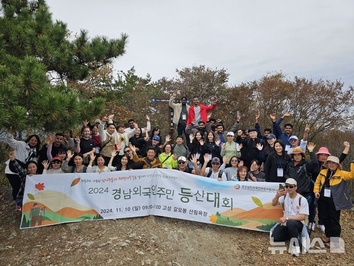 [창원=뉴시스]10일 경남 고성군 고성갈모봉 자연휴양림에서 열린 경남외국인주민지원센터 주관 '경남 외국인주민 등산대회'에 참여한 외국인주민들이 기념촬영하고 있다.(사진=경상남도외국인주민지원센터 제공02024.11.10. photo@newsis.com