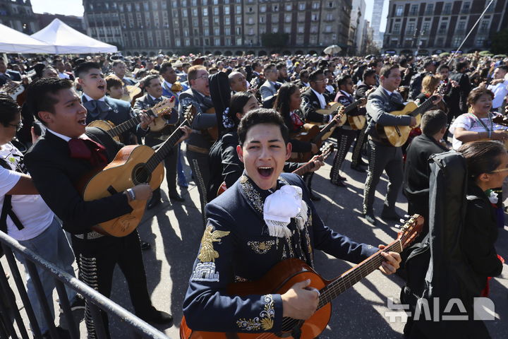 [멕시코시티=AP/뉴시스] 10일(현지시각) 멕시코 수도 멕시코시티의 소칼로 광장에서 '최다 마리아치 연주' 기네스 기록 도전자들이 악기를 연주하고 있다. '마리아치'는 멕시코의 전통 음악이자 밴드 형태를 의미하며 기타, 바이올린, 트럼펫 등의 악기로 구성된다. 이날 1천 명이 넘는 연주자가 모여 기존 700명의 기록을 깼지만, 기네스 측은 아직 공식 신기록 여부는 공표하지 않은 것으로 알려졌다. 2024.11.11.