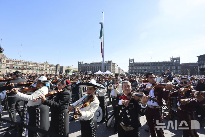 [멕시코시티=AP/뉴시스] 10일(현지시각) 멕시코 수도 멕시코시티의 소칼로 광장에서 '최다 마리아치 연주' 기네스 기록 도전자들이 악기를 연주하고 있다. '마리아치'는 멕시코의 전통 음악이자 밴드 형태를 의미하며 기타, 바이올린, 트럼펫 등의 악기로 구성된다. 이날 1천 명이 넘는 연주자가 모여 기존 700명의 기록을 깼지만, 기네스 측은 아직 공식 신기록 여부는 공표하지 않은 것으로 알려졌다. 2024.11.11.