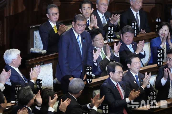 [도쿄=AP/뉴시스] 일본 집권 자민당 총재인 이시바 시게루(石破茂) 총리가 11일 총리로 재선출됐다. 지난달 1일 취임한 후 40여일 만이다. 사진은 이시바(왼쪽) 총리가 11일 중의원 총리지명선거 결선투표에서 승리한 후 의원들의 박수를 받으며 인사하고 있는 모습. 2024.11.11.
