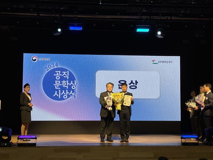 [당진=뉴시스] 지난 8일 정부 세종청사 대강당에서 당진시 이상혁 팀장(오른쪽)이 '2024년 공직문학상 작품공모전' 은상을 받은 후 관계자와 기념 촬영을 하고 있다. (사진=당진시 제공) 2024.11.11. *재판매 및 DB 금지