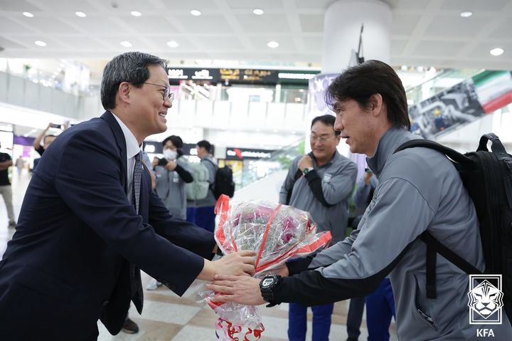 [서울=뉴시스]박종석 주쿠웨이트대사가 홍명보 감독에게 꽃다발 전달하고 있다. (사진=대한축구협회 제공)