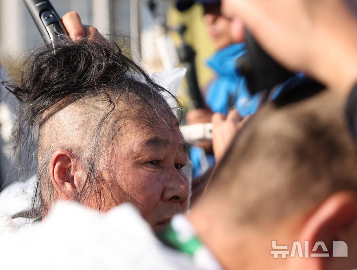 [서울=뉴시스] 김진아 기자 = 민주노총 공공운수노조 화물연대본부 조합원들이 11일 서울 여의도 국회 앞에서 '국민안전 사수! 안전운임제 입법 촉구! 화물노동자 100인 삭발 결의대회에서 삭발식을 하고 있다. 2024.11.11. photo@newsis.com