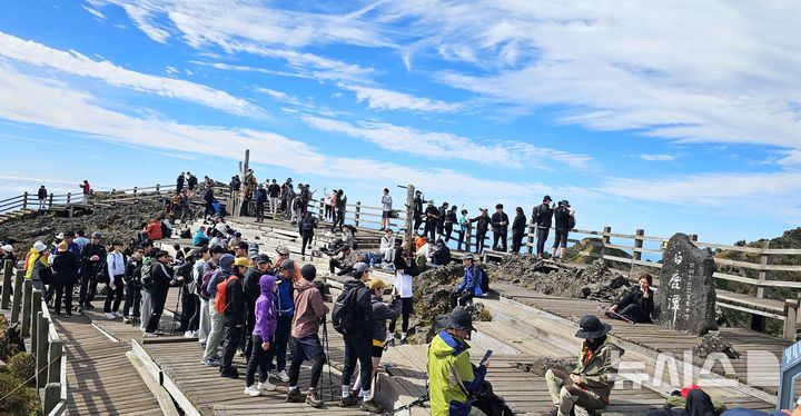 [제주=뉴시스] 임재영 기자 = 제주도는 초겨울 한라산 백록담 정상 탐방을 자유롭게 할 수 있도록 탐방예약제를 11월27일부터 한달간 한시적으로 해제하기로 했다. 10월5일 백록담 표지석에서 기념사진을 찍기 위해 탐방객들이 줄을 길게 섰다. 2024.10.05. ijy788@newsis.com