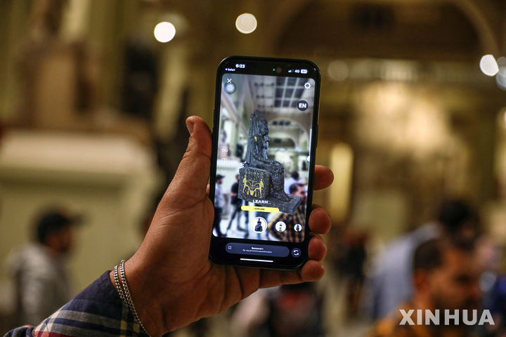 [카이로= 신화/뉴시스]&nbsp; 카이로 시내 이집트 박물관에서 한 관광객이 11월 11일 (현지시간) 휴대전화기로 고대유물 복원 앱을 실현해 그 유물의 원모습을 감상하고 있다.&nbsp; 2024.11.12.