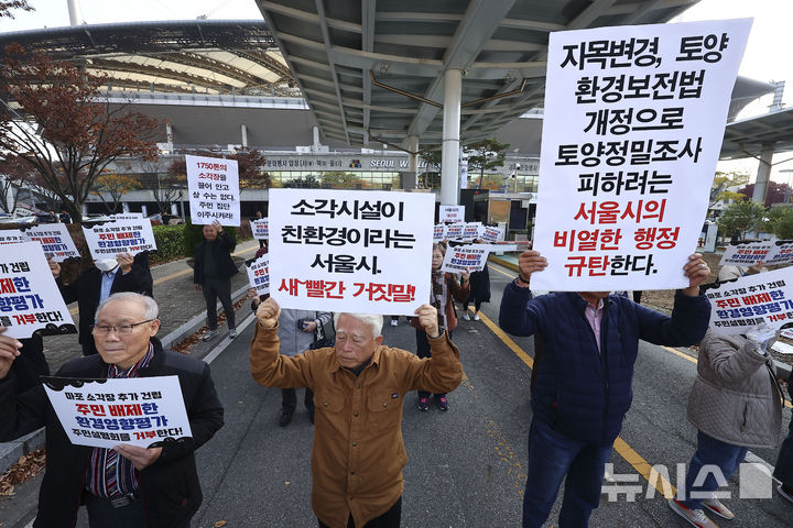 [서울=뉴시스] 김근수 기자 = 추가소각장 건립반대 범마포 다자협의체 회원들이 12일 서울 마포구 서울월드컵경기장 리셉션홀 앞에서 열린 서울시 광역자원회수시설 건립 환경영향평가(초안) 및 기후변화영향평가(초안) 주민설명회 반대 기자회견에서 구호를 외치고 있다. 2024.11.12. ks@newsis.com