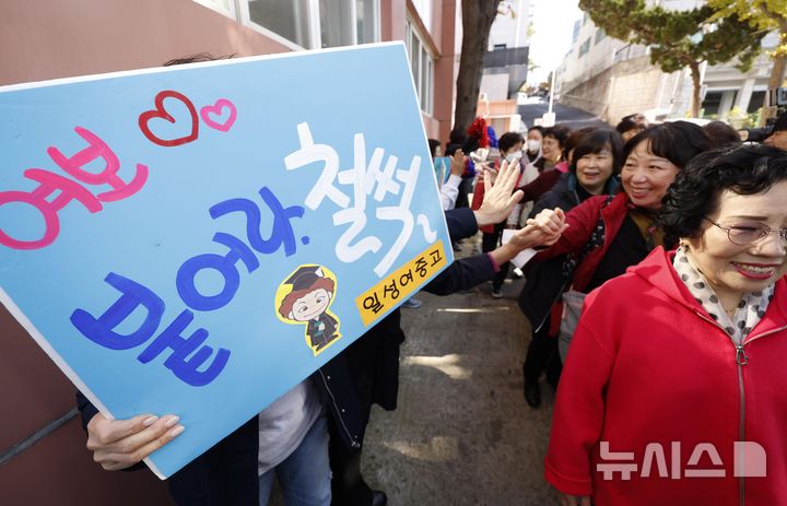 [서울=뉴시스] 김근수 기자 = 12일 서울 마포구 일성여중고에서 열린 수능시험 합격 기원 떡 전달식에 앞서 학생들이 수능 응원 문구가 담긴 피켓을 들고 2025학년도 수능을 치르는 만학도 선배들을 응원하고 있다. (공동취재) 2024.11.12. photo@newsis.com