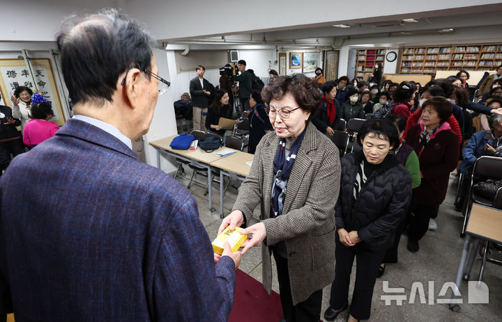 [서울=뉴시스] 김근수 기자 = 2025학년도 대학수학능력시험을 이틀 앞둔 12일 서울 마포구 일성여자중고등학교에서 만학도 수험생들이 교장 선생님에게 합격 기원 떡을 받고 있다. (공동취재) 2024.11.12. photo@newsis.com