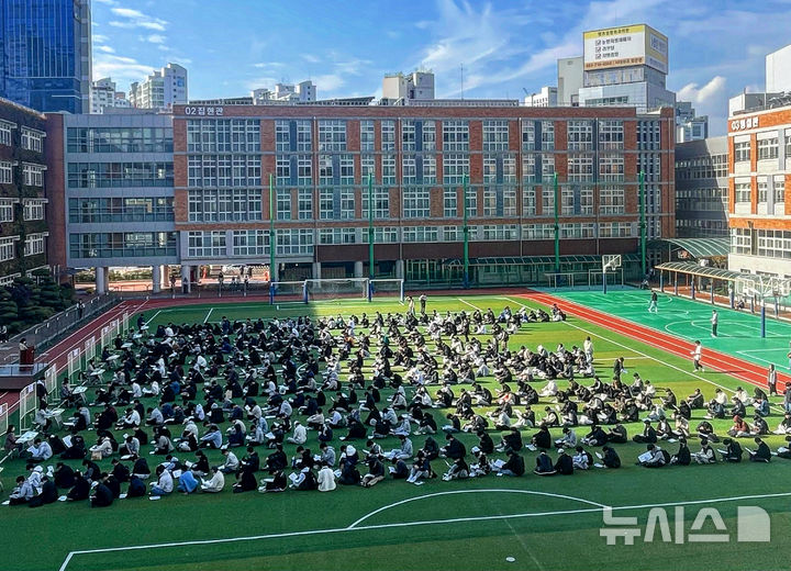 [대구=뉴시스] 정재익 기자 = 2025학년도 대학수학능력시험을 하루 앞둔 13일 대구 중구 경북대학교 사범대학 부설고등학교 운동장에서 수험생들이 수험표를 받기 위해 줄지어 앉아 있다. 2024.11.13. jjikk@newsis.com