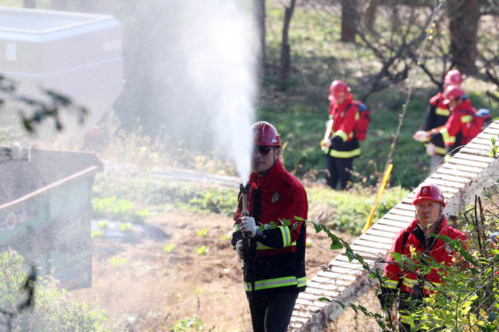[광주=뉴시스] 박기웅 기자 = 광주 북구 공원녹지과 산림팀 산불진화 대원들이 13일 산불조심 기간을 맞아 운정동 한 야산에서 등짐펌프를 이용해 물을 뿌리며 산불 진화 훈련을 하고 있다. 사진은 기사와 직접적 관련 없음. (사진 = 광주 북구 제공) 2024.11.13. photo@newsis.com *재판매 및 DB 금지