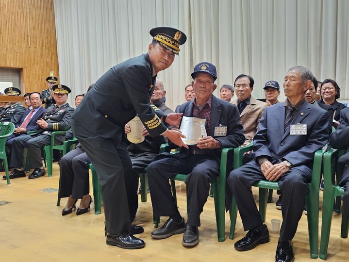 [서산=뉴시스] 김덕진 기자=13일 충남 서산 부석초등학교 웅비관에서 육군 제32보병사단 김관수 사단장이 부석초등학교 6·25 참전용사에게 미니 명패를 건네며 기념 사진을 찍고 있다. 2024.11.13. spark@newsis.com *재판매 및 DB 금지