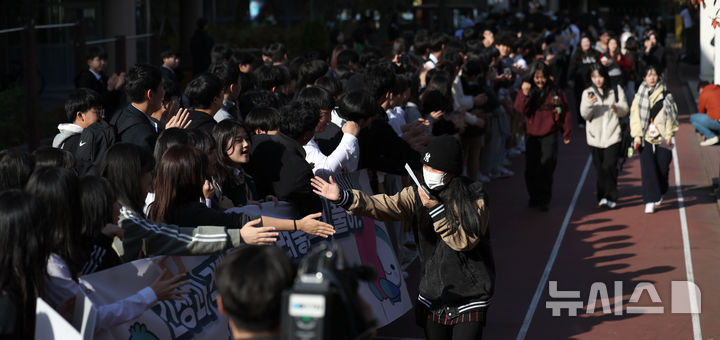 [서울=뉴시스] 김선웅 기자 = 2025학년도 대학수학능력시험을 하루 앞둔 13일 서울 성동구 성수고등학교에서 고3 수험생들이 후배들의 응원을 받으며 하교하고 있다. 2024.11.13. mangusta@newsis.com