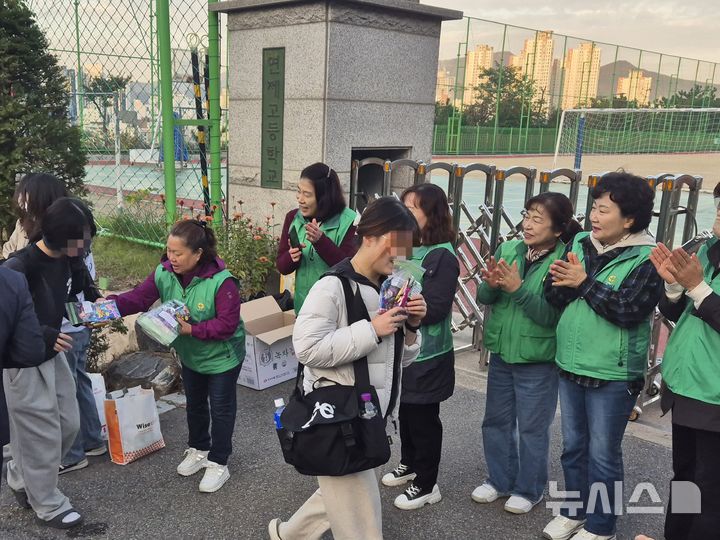 [부산=뉴시스] 김민지 기자 = 2025학년도 대학수학능력시험 날 14일 오전 부산 연제구 연제고등학교 앞에서 지역 새마을회 회원들은 수험생들에게 간식 꾸러미를 나눠주고 있다. 2024.11.14. mingya@newsis.com