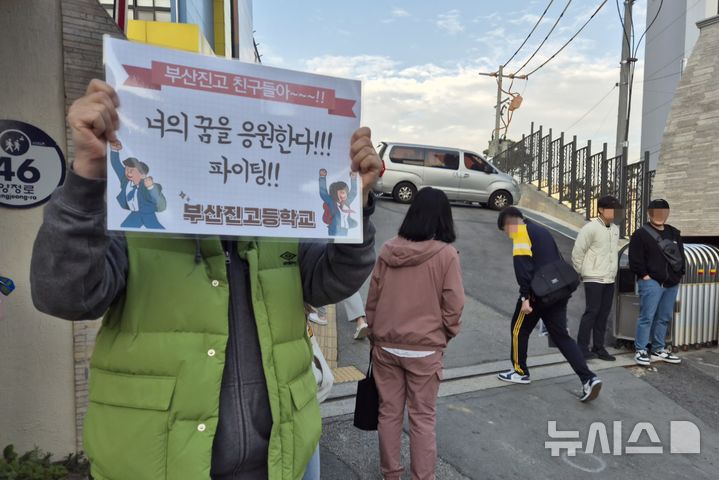 [부산=뉴시스] 권태완 기자 = 2025학년도 대학수학능력시험 날인 14일 오전 부산진구 부산진고등학교 앞에서 한 교사가 수험생 응원 피켓을 들고 있다. 2024.11.14. kwon97@newsis.com