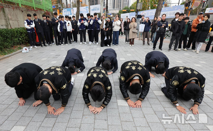 [서울=뉴시스] 김금보 기자 = 14일 오전 서울 강남구 개포고등학교에 마련된 2025학년도 대학수학능력시험 서울특별시교육청 제18시험지구 제7시험장에서 중동고등학교 학생들이 수험생 선배들이 입실해 있는 시험장을 향해 큰절을 하고 있다. 2024.11.14. kgb@newsis.com