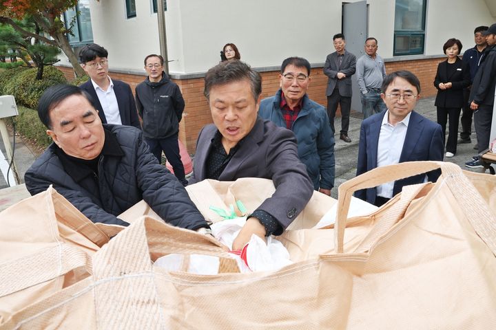 [정읍=뉴시스] 이학수 정읍시장이 15일 덕천면 공공비축미 매입현장을 찾아 배임상황을 점검하고 농업을 격려했다. 이 시장(오른쪽)과 유남영 정읍농협장(왼쪽)이 올해 수확한 벼의 상태를 살피고 있다. (사진=정읍시 제공) 2024.11.15. photo@newsis.com *재판매 및 DB 금지